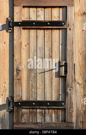 Rustic wooden door with metal hardware details in vertical format Stock Photo