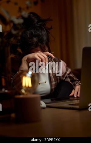 tired graphic designer woman working at home office remotely using digital graphic tablet and laptop Stock Photo