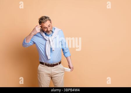 Businessman gestures thoughtfully, indicating question or reflection, wearing stylish casual attire on soft beige background Stock Photo