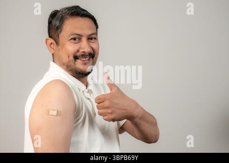Smiling man getting vaccinated in the arm, showing no fear and promoting vaccine confidence. Stock Photo