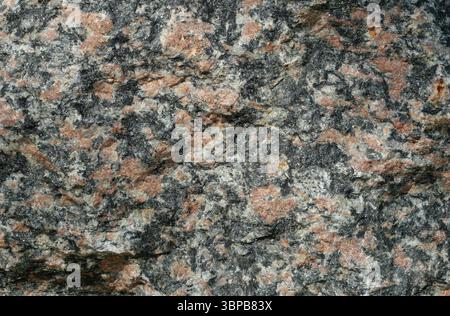 Texture of red-black marbled granite boulder. Natural stone as landscape element. Copyspace. Stock Photo