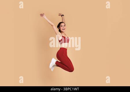 Smiling Young Woman Jumping Isolated On Pink Background Stock Photo