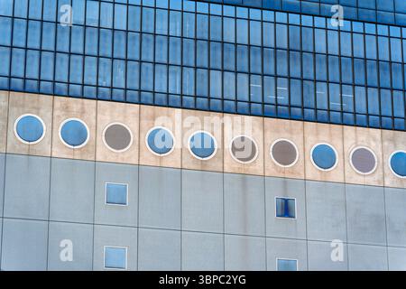 Closeup artistic modern architectural building using circular and square windows to create rhythmic and futuristic facade design Stock Photo