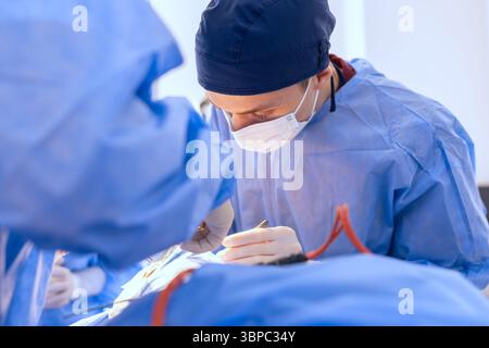 male surgeons perform surgery in operating room, plastic surgeon in operating room. Stock Photo