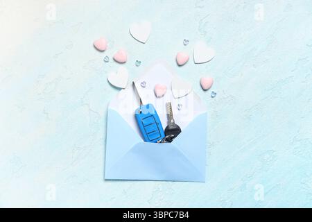 Envelope with car keys and hearts on light grunge background Stock Photo