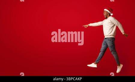 Check This. Excited Black Santa Guy Pointing Aside At Copy Space Stock Photo