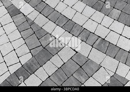 Geometric pavement design with alternating dark and light tiles in a monochromatic black and white color scheme. Stock Photo