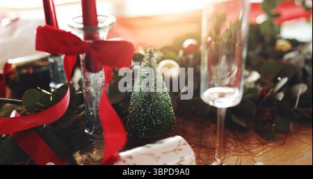 Christmas, decorations and champagne glass on table in dining room for festive celebration, event or lunch. Holidays, place setting and tree for xmas Stock Photo