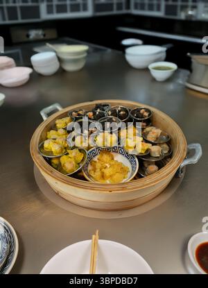 Intricate details of perfectly steamed pork wonton dumplings, showcased in a rustic bamboo basket. Each pleat highlights the tender filling Stock Photo