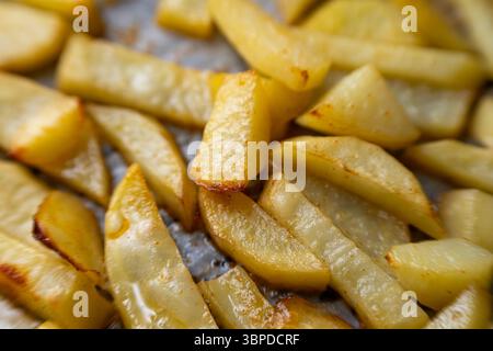 Homemade golden potato wedges baked in the oven, close-up Stock Photo