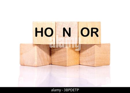 The HONOR concept word is assembled from wooden cubes. ethics, respect, code, honesty, integrity concept. Stock Photo