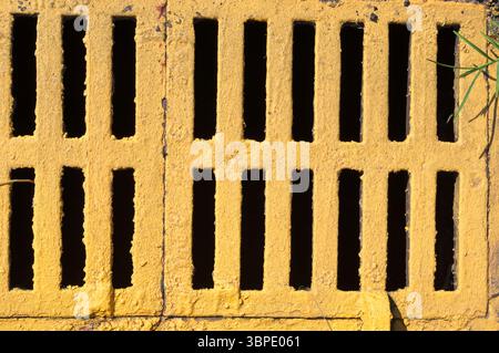 Close up of a municipal storm drain grate painted yellow Stock Photo
