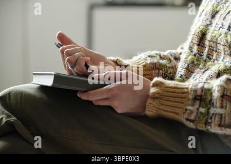 Young Woman Taking Notes during Therapy Session Indoors Stock Photo