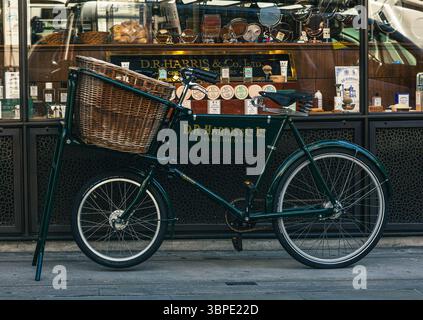 Vintage cargo bicyle in front of D. R. Harris & Co Pharmacy on St James's Street. Stock Photo