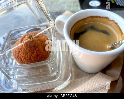 Cup of coffee and small cake in jar as served in a café or coffee shop Stock Photo