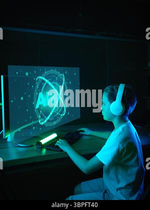 Boy with headphones working on AI project with holographic interface Stock Photo