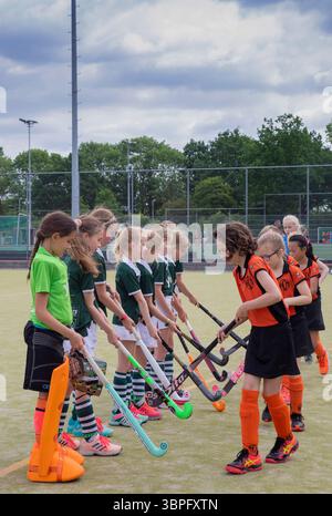 Netherlands, children are going to play a hockey match and wish each other a pleasant match beforehand by hitting their hockey sticks against each oth Stock Photo