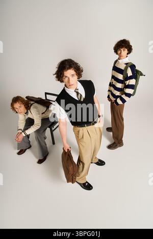 Three young men display their unique fashion sense while posing creatively in a studio. Stock Photo