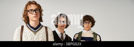 Three young men confidently display their unique fashion styles in front of the camera. Stock Photo