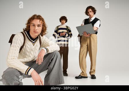 Three young men display their unique styles while enjoying a shared creative vibe in a studio. Stock Photo