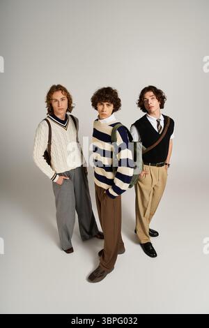Three young friends display their individual styles while posing confidently together indoors. Stock Photo