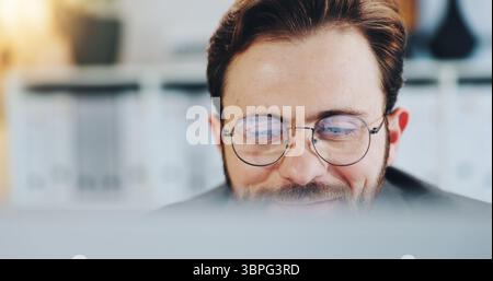 Smile, man and reading on computer in office for editor feedback, information and article post. Male journalist, glasses and reflection of PC for Stock Photo