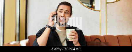 man engages in a phone conversation while savoring a matcha drink, banner Stock Photo