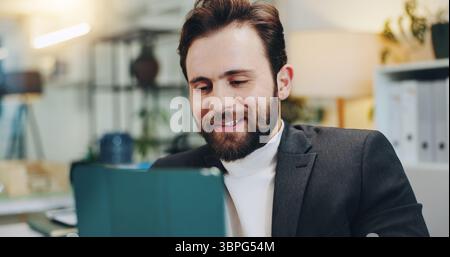 Smile, man and reading on tablet in office for editor feedback, information and article post. Male journalist, digital and proofreading of latest news Stock Photo