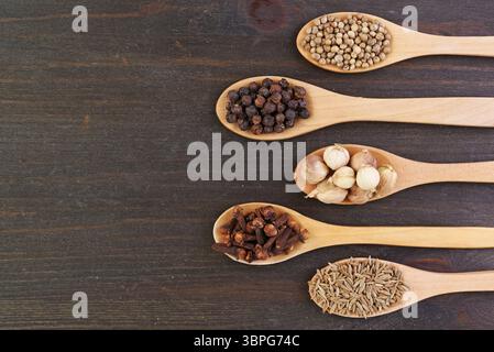 Assortment of Spices in Wooden Spoons on Black Wooden Background Stock Photo