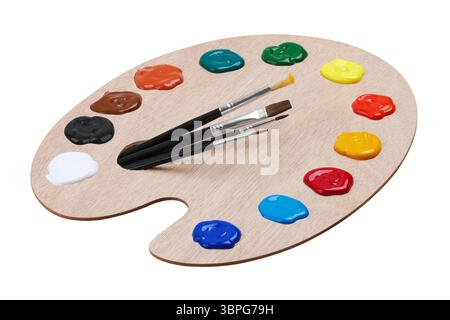 Wooden art palette with paints and brushes, isolated on white background Stock Photo