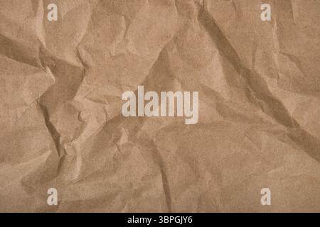 Abstract paper background. Wrapped kraft paper with a crushed texture. Background for design with a copy space. Concept of using recycled materials Stock Photo