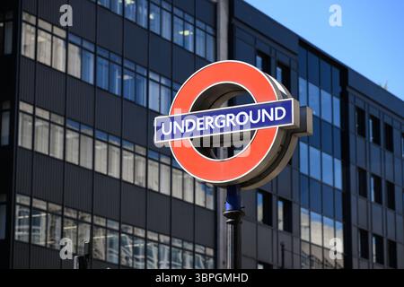 London, UK - April 2, 2025 London Underground roundel on pole against building Stock Photo