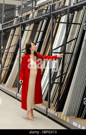 Pregnant woman browsing through a variety of construction materials while shopping in a home improvement store for her renovation project Stock Photo