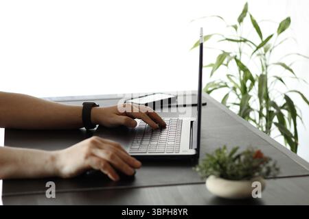Close-Up of Hands Typing on Laptop Keyboard in Modern Workspace Stock Photo
