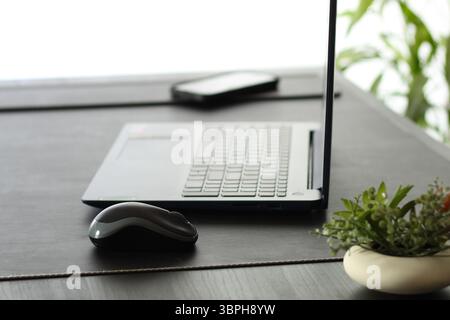 Open Laptop on Dark Desk Against Clean White Background Stock Photo