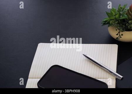 Phone and Blank Open Notebook with Pen on Desk Ready for Writing Stock Photo