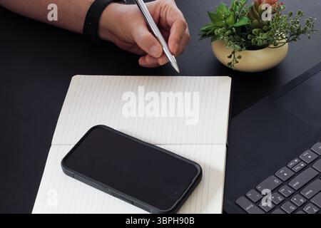 Close-Up of Pen Tip Hovering Above Blank Notepad Page Stock Photo