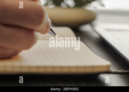 Close-Up of Pen Tip Hovering Above Blank Notepad Page Stock Photo