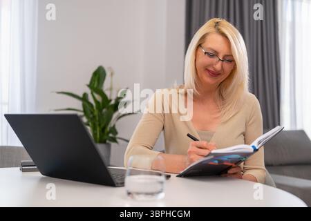 Thoughtful mature therapist taking notes while working with clients. Concept of professional counseling, psychology, and support. Stock Photo
