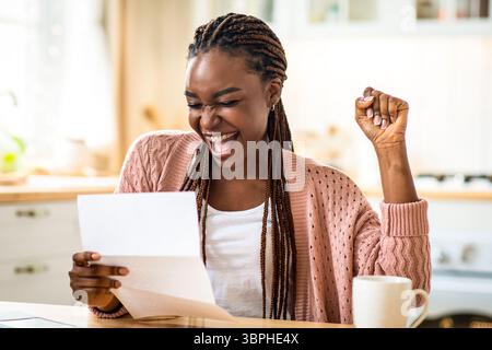 Good News. Portrait Of Overjoyed African American Lady Reading Letter In Kitchen Stock Photo
