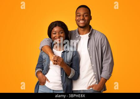 Portrait of joyful smiling black couple embracing and smiling at camera Stock Photo