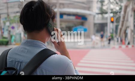 Professional businessman checking smartphone near urban crosswalk Stock Photo