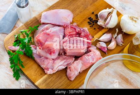 Delicious cutting rabbit meat with spices and herbs on kitchen board Stock Photo