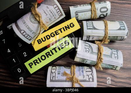 Concept of Budgeting priorities write on sticky notes isolated on Wooden Table. Stock Photo