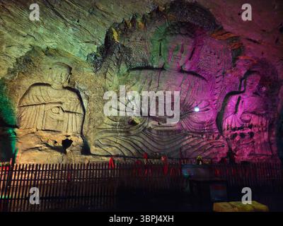Illuminated Karst Cave Buddha Carvings in Shandong China Stock Photo
