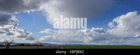 Panoramic photo of a forming thunderstorm or supercell moving across the country, with clear clouds and horizon over fields Stock Photo