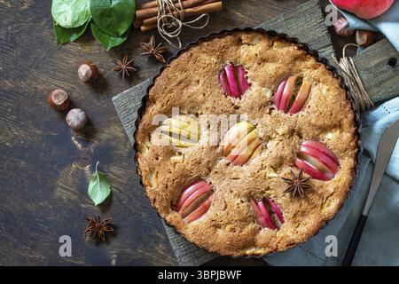 Apple baking gluten free seasonal. Autumn pie with apples, hazelnut and cinnamon on a wooden table. Top view flat lay background. Copy space Stock Photo