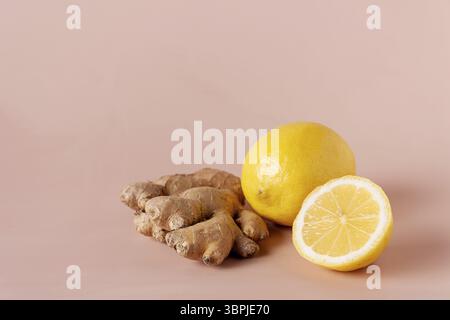 Ginger root and lemons lie on a beige background, close-up Stock Photo