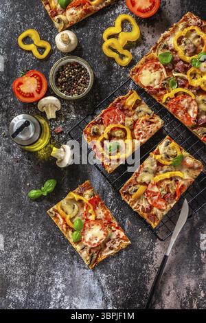 Homemade baking Detroit-Style pizza. Large rectangular Pepperoni pizza with mushrooms, salami and cheese on a stone tabletop. Top view flat lay backgr Stock Photo