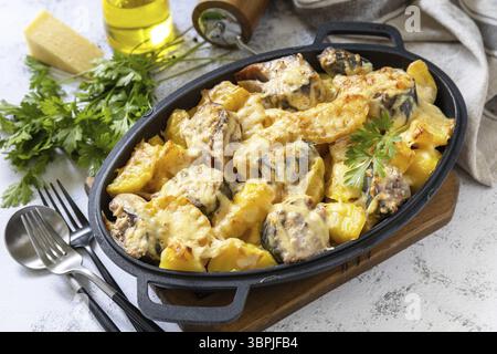 Baked mackerel with potatoes and cheese on a marble tabletop Stock Photo